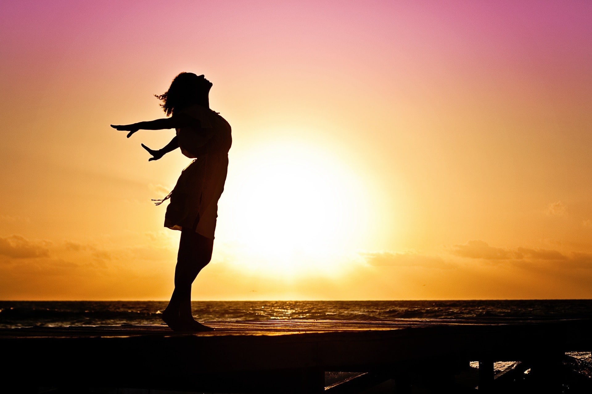 Qi Gong_als_Heilungsweg_Frau_Sonnenuntergang_Arme_Hinten_Meer